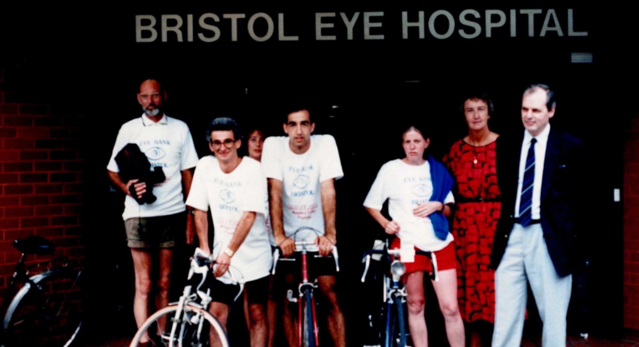A group of people including Graham (2nd left) & Prof Easty (far right) in front of the Bristol Eye Hospital