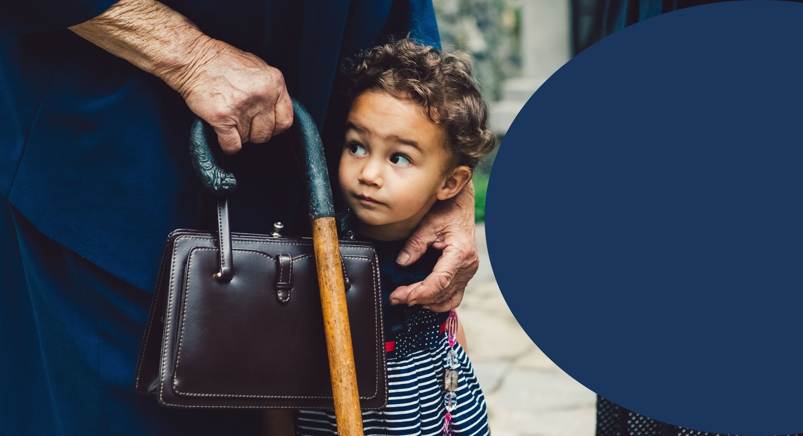 Grandparent with arm around child standing outside