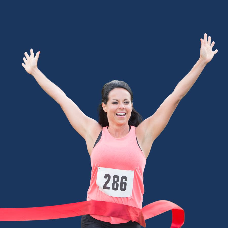 Person crossing finish line with arms raised in celebration
