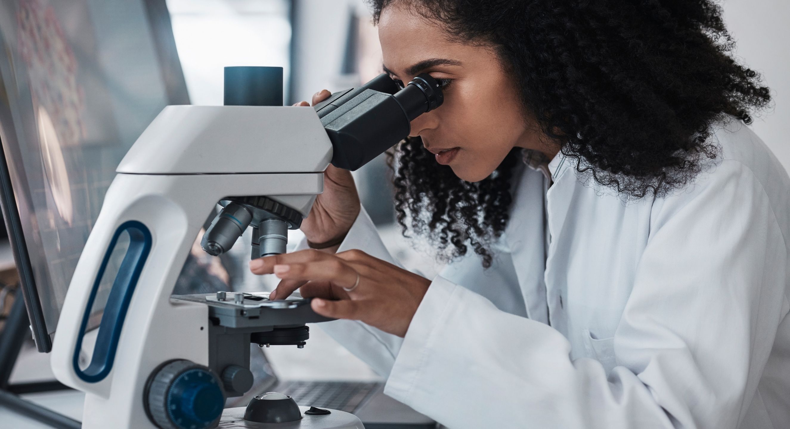 Researcher looking into a microscope