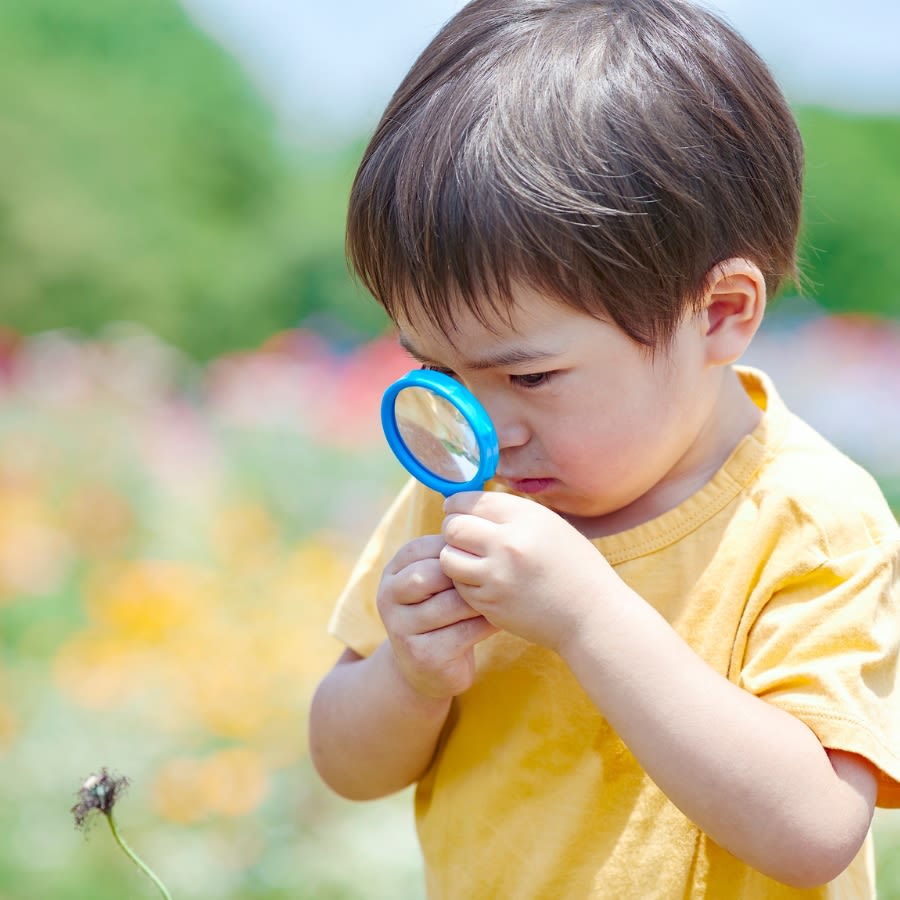 A child holding a magnifying glass outside