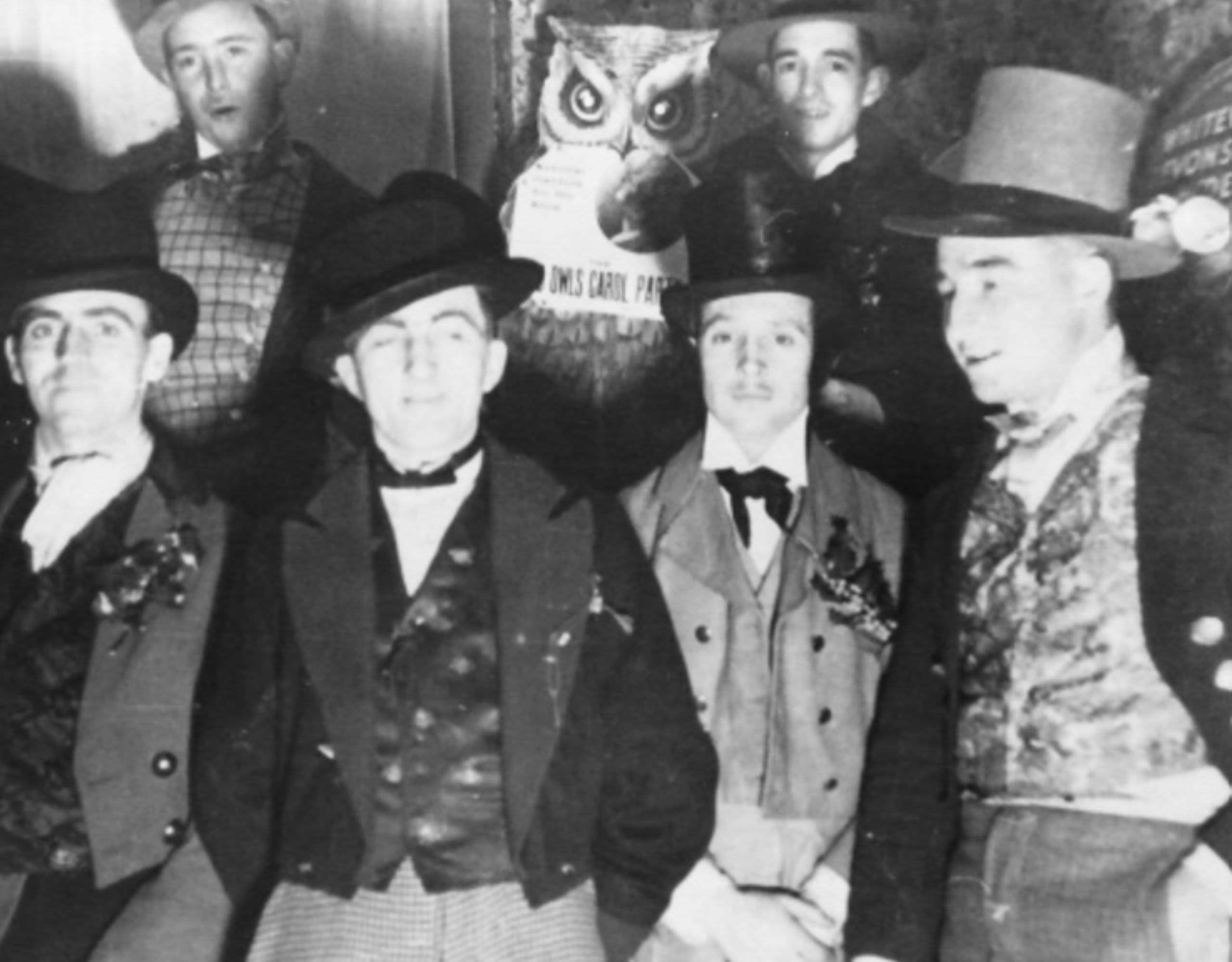 Black and white photo of Owls of Pill in early to mid 1900s wearing top hats and waistcoats